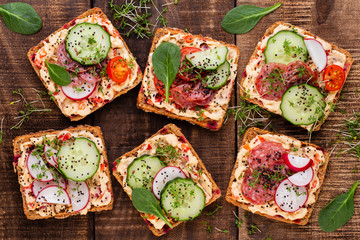 Sandwiches with cream cheese, vegetables and salami.