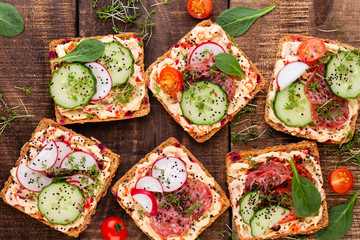 Sandwiches with cream cheese, vegetables and salami.