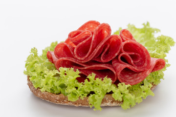 Sandwich with salami sausage on white background.