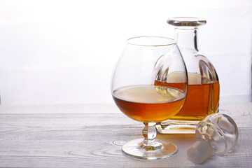 Glass and glass decanter with alcohol. Cognac Decanter. Carafe of brandy.
