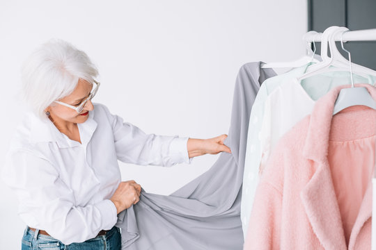 Senior fashion style. Shopping and clothing options. Elderly lady choosing outfit.