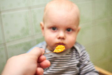 A boy with a closed mouth does not want to eat