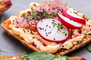 Sandwiches with cream cheese, vegetables and salami.