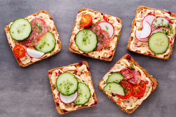 Sandwiches with cream cheese, vegetables and salami.