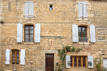 Fototapeta na wymiar Old stone house with wooden shutters in Domme. Perigord, France