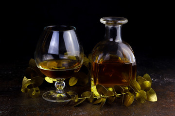 Glass, decanter with alcohol and golden floral design elements. Cognac Decanter on dark background....