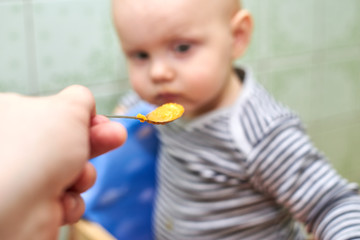 A boy with a closed mouth does not want to eat