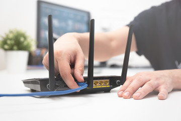 Man connects the internet cable to the router