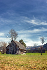 Old wood shack or cabin in the woods against beautiful mountain with snow