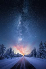 Fototapete Nordlichter Straße, die zu farbenfrohem Sonnenaufgang zwischen schneebedeckten Bäumen mit epischer Milchstraße am Himmel führt