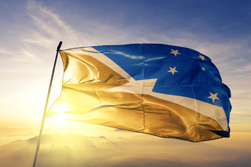 Tierra del Fuego province of Argentina flag waving on the top sunrise mist fog