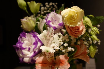 Beautiful wedding bouquet composed of different flowers on a black background.