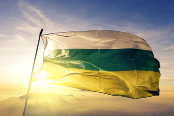 Huila department of Colombia flag waving on the top sunrise mist fog