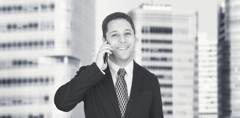 Businessman Talking On The Phone With Business City and Corporate Buildings In Background