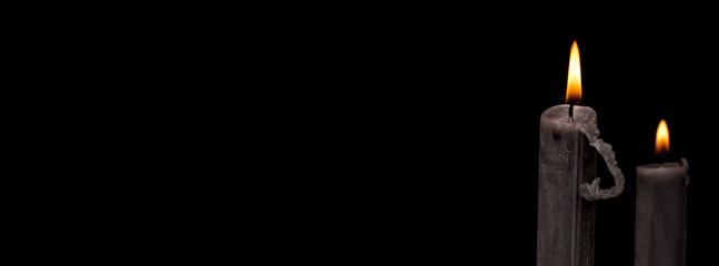 burning candle on black background