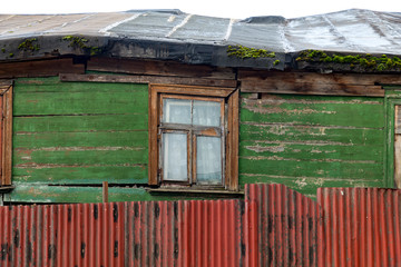 wall of an old house with crooked window