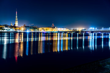 Fototapeta na wymiar Ciity rflection at night in the river Daugava