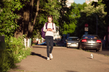 Child is walking with smartphone at sunset