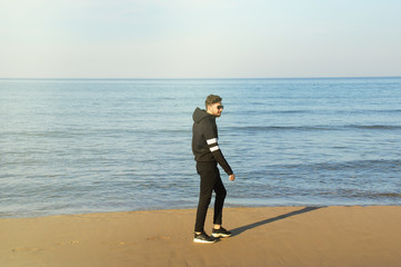 Young man walking at the beach
