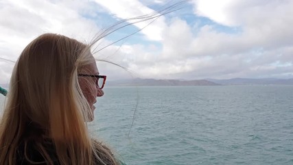 Beautiful blonde lady enjoying the sea view from the vessel