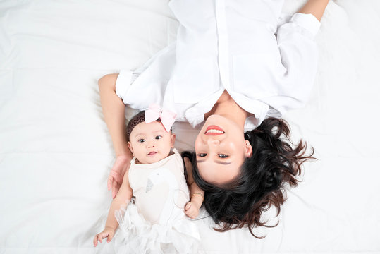 Woman with a baby doing a selfie lying on wooden floor