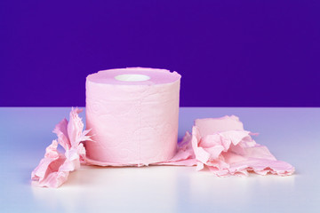 Toilet paper rolls isolated on white table with purple background