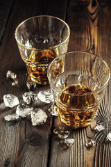 Whiskey and ice on rustic wood background
