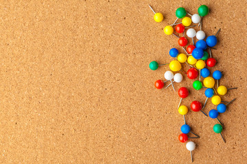 Group of colorful push pins on cork bulletin board