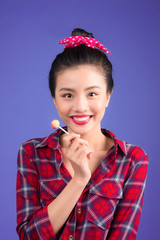 A glamorous girl eats chupachups, looks into the camera.