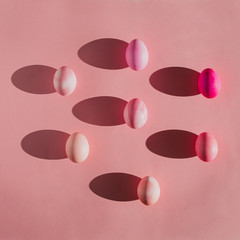 Overhead view of Easter eggs with shadows on pink background