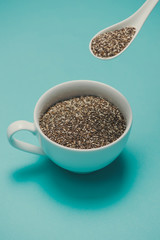 Cup of healthy chia seeds and spoon. Text space.