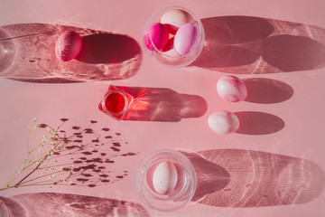 Overhead view of Easter eggs with shadows on pink background