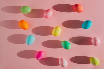 Overhead view of Easter eggs with shadows on pink background