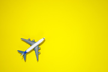 Minimal layout with model airplane on yellow background. Directly above. Travel vacation summer concept. top view, flat lay composition.