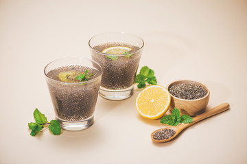 Selective focus of chia seeds drink with water in transparent glass with lemon balm.