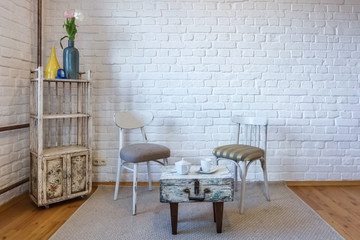 table, chairs, shelves on the background of a white brick wall in vintage loft interior
