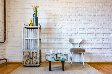 table, chairs, shelves on the background of a white brick wall in vintage loft interior