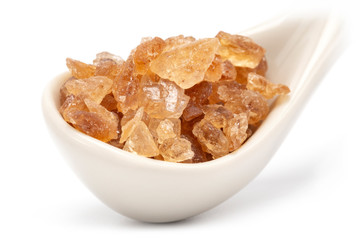 A close-up of rock sugar in porcelain spoon