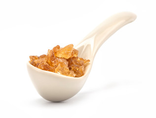 A porcelain spoon with rock sugar inside