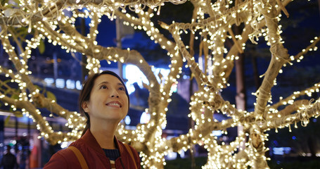 Woman enjoy watching the Christmas decoration at night
