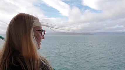 Beautiful blonde lady enjoying the sea view from the vessel