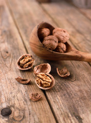 walnuts on a rustic wooden table - close up - walnuts broken up and closed