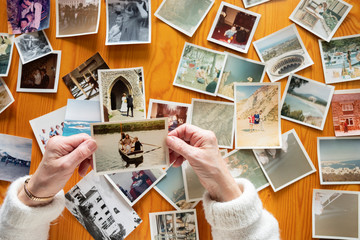 Top view of a senior caucasian woman looking at an old photos themes of memories nostalgia photos...