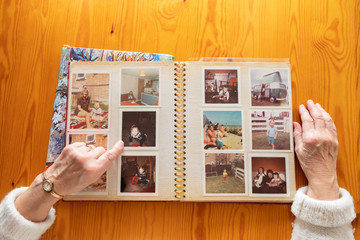 Top view of a senior caucasian woman looking at an old photo album themes of memories nostalgia photos retired - obrazy, fototapety, plakaty