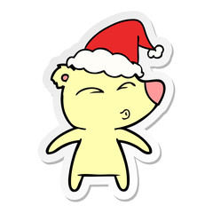 sticker cartoon of a whistling bear wearing santa hat