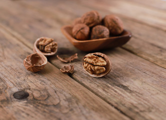 walnuts on a rustic wooden table - close up - walnuts broken up and closed