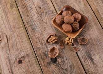 walnuts on a rustic wooden table - close up - walnuts broken up and closed