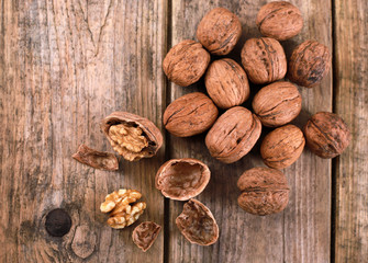 walnuts on a rustic wooden table - close up - walnuts broken up and closed