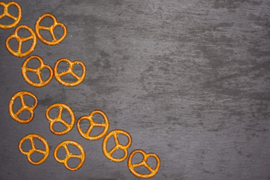 Lot of whole mini salted pretzels  with copyspace flatlay on grey stone