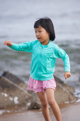 真夏の海の砂浜で遊んでいる子供